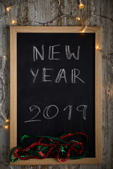 Black chalkboard with the written words NEW YEAR 2019