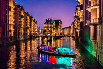 The Warehouse District (German: Speicherstadt) in Hamburg, Germany. A colorfully illuminated disco...