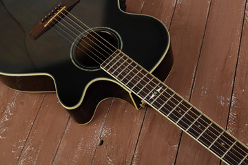 Plakat Musical instrument - Fragment brown cutaway acoustic guitar wood background