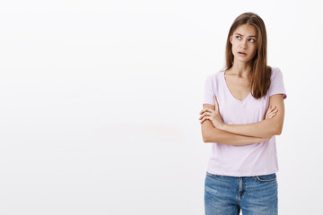 Woman trying understand what boyfriend meant. Focused clueless, confused attractive stylish young woman holding hands crossed on chest raising eyebrow, gazing at upper left corner recalling situation