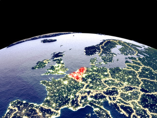 Benelux Union from space on planet Earth at night with bright city lights. Detailed plastic planet surface with real mountains. - obrazy, fototapety, plakaty