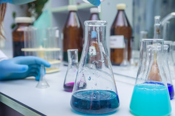 Laboratory glassware with multi-colored liquid on table. Chemical analysis