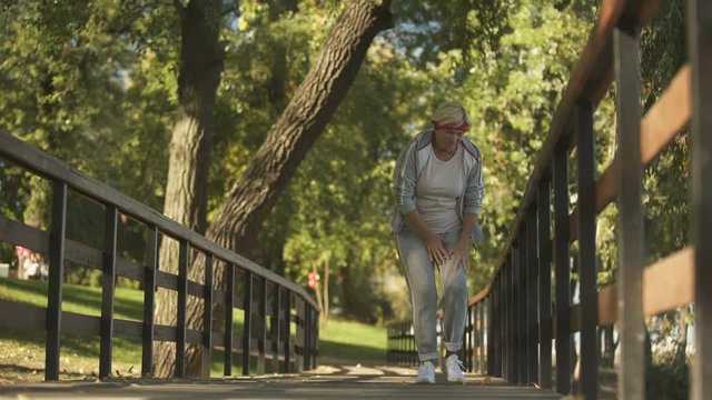 Middle aged woman suddenly feeling cramp in her leg while running, health