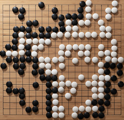 Go pieces on wooden board view from above, closeup to center board