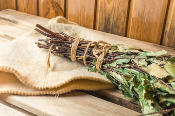 Birch broom lies on a white hat in a bath