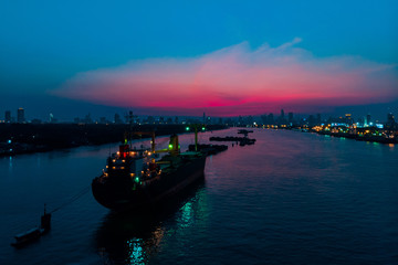 Fototapeta premium Container cargo ship in the ocean at twilight sky, Business International trade and Container logistics export-import harbor to the International port / Shipping Containers concept