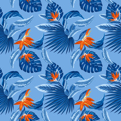 seamless pattern of tropical blue palm leaves, monstera  leaves  and coral flowers of the bird of paradise (Strelitzia) plumeria on a light blue background. Wallpaper trend design.