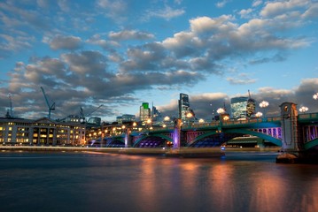 Southwark Bridge from the south bank of the River Thames in the early evening.