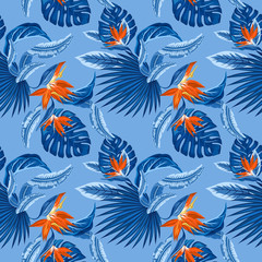 Fototapeta na wymiar Vector seamless pattern of tropical blue palm leaves, monstera leaves and coral flowers of the bird of paradise (Strelitzia) plumeria on a light blue background. Wallpaper trend design.