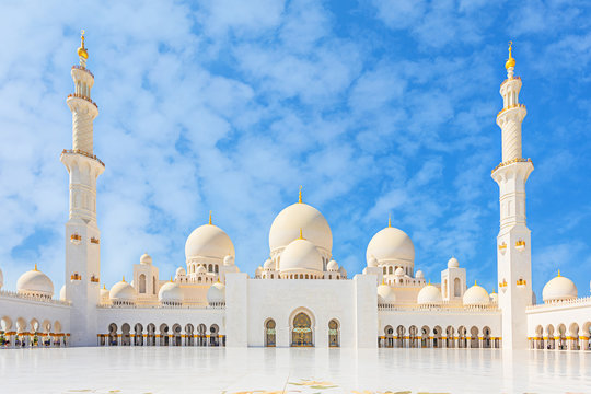 Sheikh Zayed Mosque - Abu Dhabi, United Arab Emirates. Beautiful white Grand Mosque courtyard with unique marble floor and minarets in each corner.	