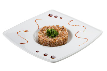 Buckwheat porridge with mushrooms and herbs. Vegetarian dish. On white background.