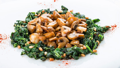 Fried mushrooms with cream of spinach. Vegetarian dish. On white background