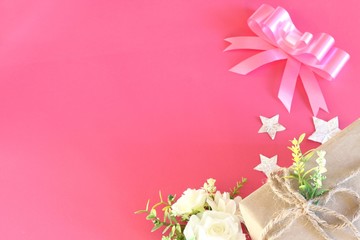 Gift box wrapped in recycled paper on pink background