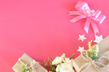 Gift box wrapped in recycled paper on pink background