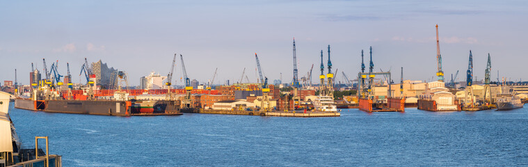 Aerial view of Hamburg Harbor, Germany, with docks and cranes in the evening sun.