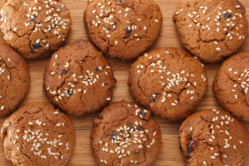 Pattern of oatmeal cookies with dried berries and sesame. View from above.