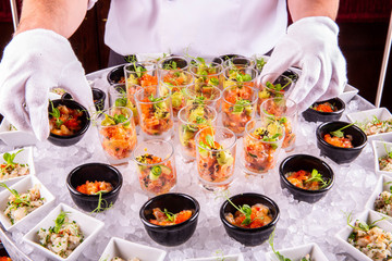Squids, a humpback salmon, a trout and a salmon in portion glasses in ice