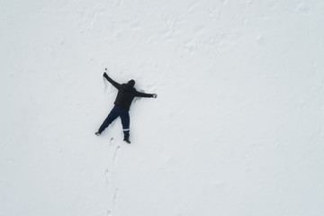 Drunk man lying in the snow. In his hand empty bottle of alcohol