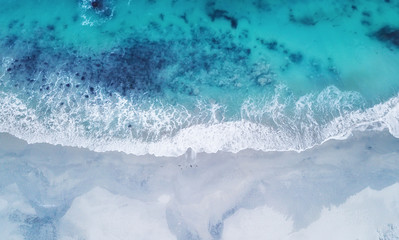 Fototapeta na wymiar Beach and waves from top view. Turquoise water background from top view. Summer seascape from air. Top view from drone. Travel concept and idea