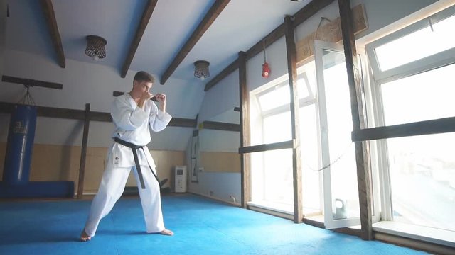 Young man training karate, sport and fitness at gym. Slow motion