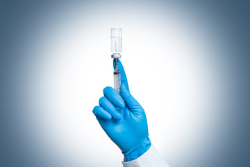 the doctor's hand in blue gloves is holding a medical syringe for injections, vaccinations against...