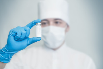 the medical doctor holds a vial of white powder