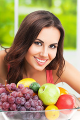 smiling woman with plate of fruits