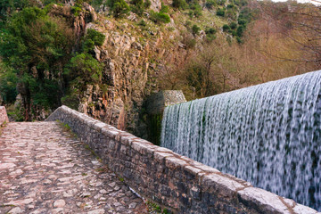 Close up of the stone arched bridge of Palaiokarya village with its impressive waterfall in Trikala, Greece