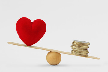Heart and money on balance scale - Concept of money priority in life