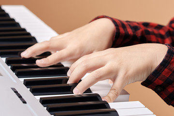 Obraz premium Kid’s hands on the electric synthesizer playing a melody.