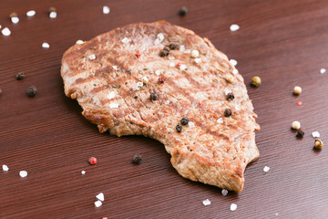 Grilled beef steak on the table. A piece of marbled beef fried in a pan grill close-up.