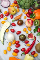 Different vegetables and fruits on a wooden background top view.