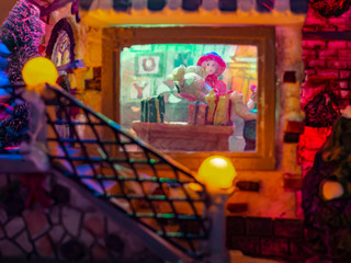 Obraz na płótnie Canvas Tiny people walking in the city at night, Christmas village macro, holidays, closeup, festive, toy houses, model city, happy holidays.