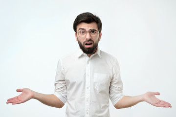 Fototapeta premium Hispanic man in white shirt throws up his hands in disbelief like saying I am not sure now.