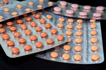 Orange and pink medical tablets in pack, tablets and capsules and tablets packed in blisters. Full...