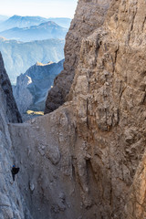Male mountain climber on a Via Ferrata in breathtaking landscape of Dolomites Mountains in Italy. Travel adventure concept.