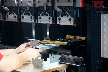 The technician operator use hydraulic bending machine. The sheet metal manufacturing process.