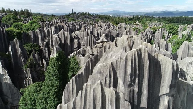 Rising drone shot reveals beautiful karst limestone rock formations of Shilin Stone Forest in China