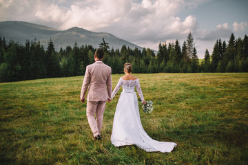 bride and groom walking hand by hand