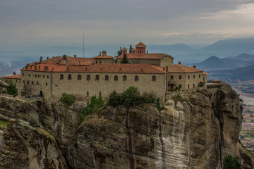 Fototapeta na wymiar lonely Christian monastery building landmark on top of rock dramatic scenic mountain environment in autumn cloudy season weather, world heritage touristic site and sightseeing concept