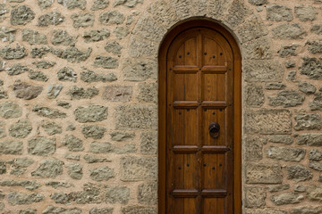 wooden arch door frame in medieval castle building stone wall background texture, exterior architecture design concept