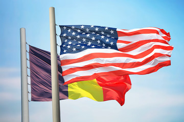 Flags of the USA and Belgium against the background of the blue sky
