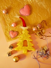 Decorative seasonal composition from a decorative Christmas tree gingerbread in a Santa hat, pink felt hearts, balls, boxes with decor on a bright background, top view, winter holidays Christmases, va