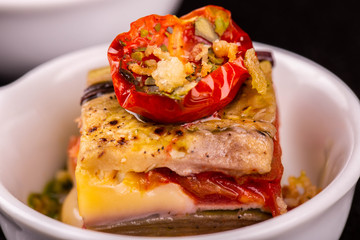 Grilled vegetables under hot sauce with seasonings and a tomato