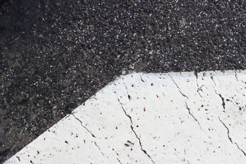 Asphalt pavement sign marking crosswalk white paint wet old surface texture detail