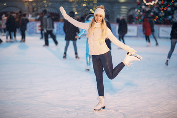 Young woman with skates on the ice rink