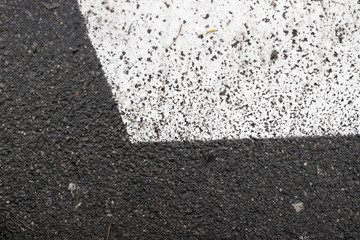 Fototapeta premium Asphalt pavement sign marking crosswalk white paint wet old surface texture detail