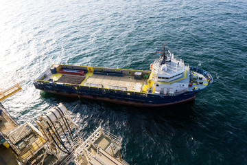 Cargo vessel next to oil rig getting ready to offload casings