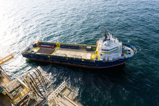 Cargo vessel next to oil rig getting ready to offload casings