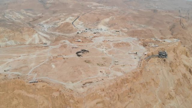 Masada - Aerial footage of the ancient fortification in the Southern District of Israel. Israeli soldiers on top of the mountain. Moving forward. Flying over Masada. The view from the top. 4k